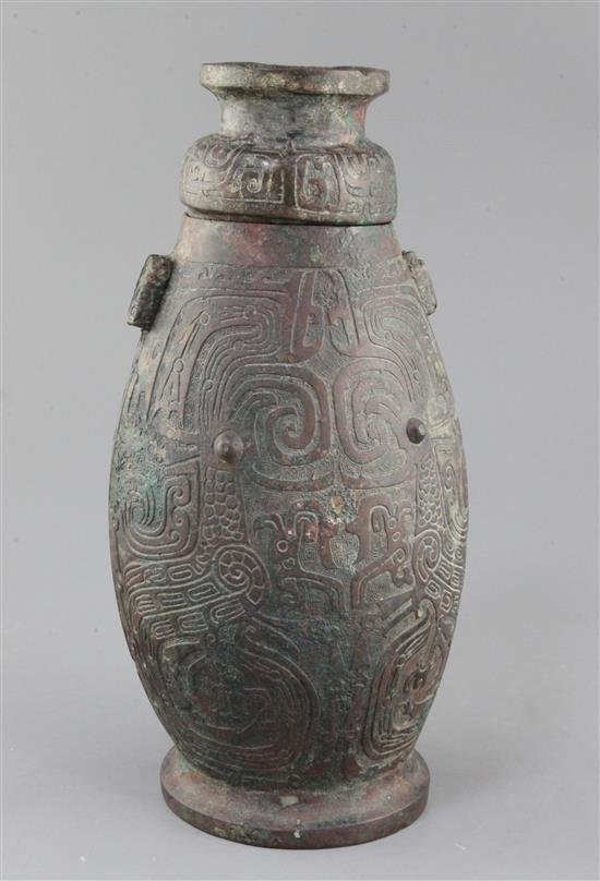 A Chinese archaic bronze ritual drinking vessel and cover, Hu, Western Zhou dynasty, 11th-9th century B.C., 30cm high, faults